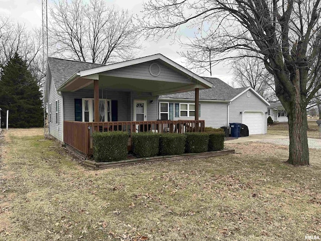 view of front of home with a garage, a front yard, and covered porch