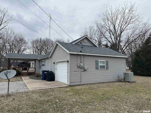 view of side of home with central AC unit, a garage, and a yard