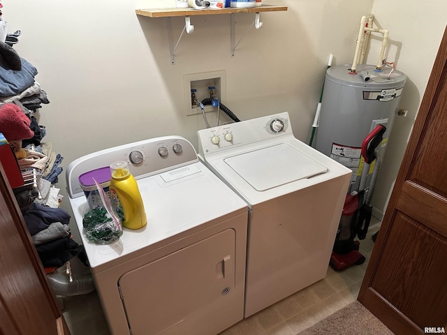 clothes washing area featuring electric water heater and washer and clothes dryer