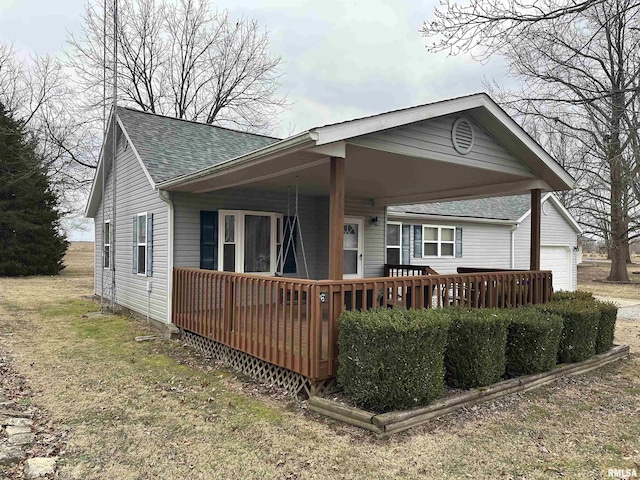 back of property featuring a garage and a yard