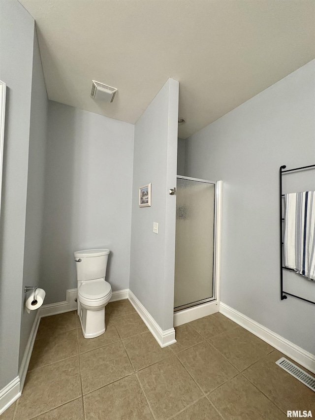 bathroom with tile patterned floors, toilet, and walk in shower