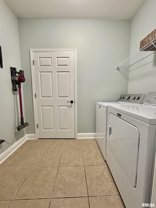 washroom with washing machine and clothes dryer and light tile patterned floors