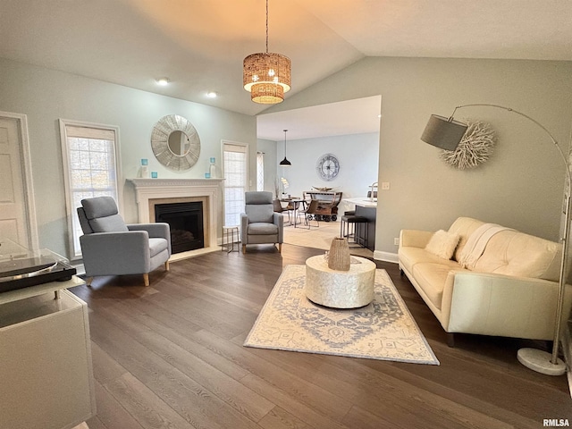 living room with plenty of natural light, dark hardwood / wood-style flooring, and vaulted ceiling