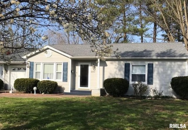 ranch-style house featuring a garage and a front lawn