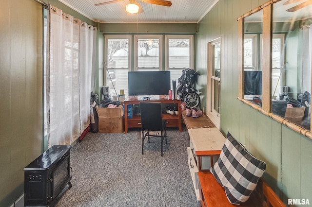 carpeted home office featuring ceiling fan and wood walls