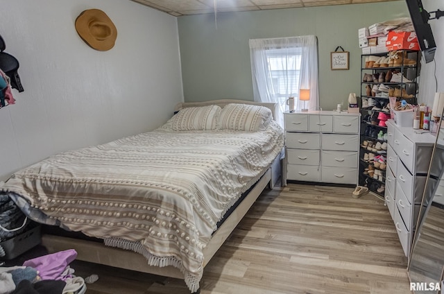 bedroom with light hardwood / wood-style flooring and a drop ceiling