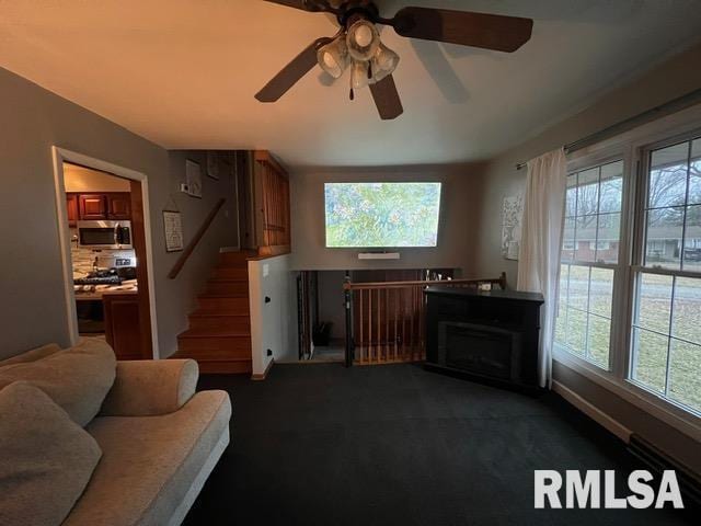 living room featuring dark colored carpet and a healthy amount of sunlight