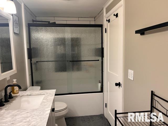 full bathroom featuring vanity, toilet, and combined bath / shower with glass door