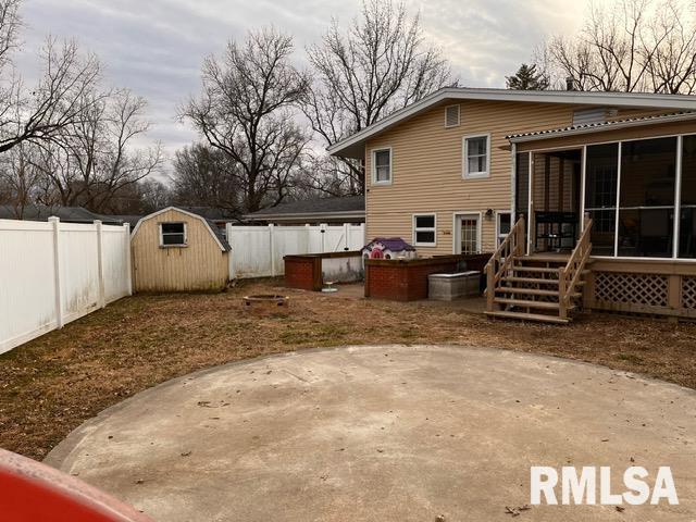 back of house with a shed, a patio area, and a sunroom