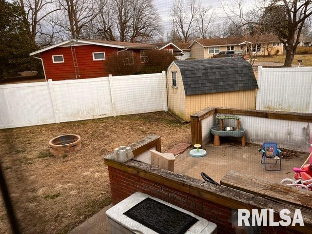 view of yard with a shed and an outdoor fire pit