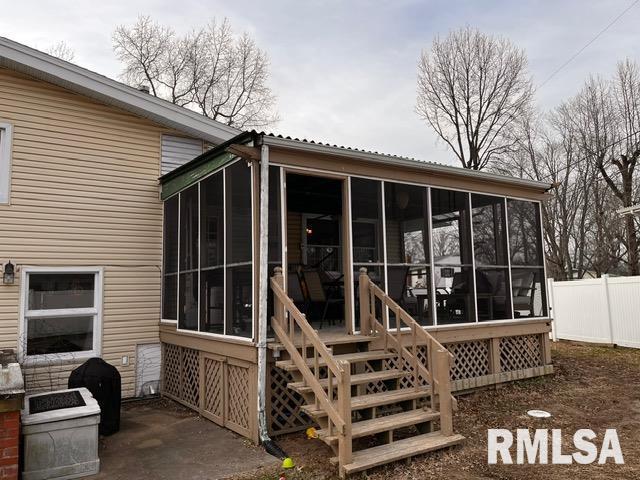 rear view of property featuring a sunroom