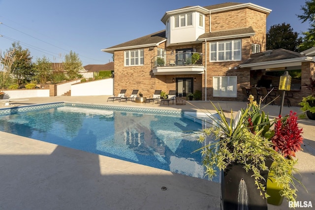 rear view of house featuring a balcony and a patio area