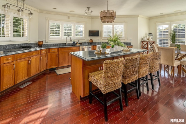 kitchen featuring sink, decorative light fixtures, a center island, dark hardwood / wood-style floors, and dishwasher