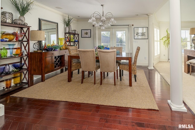 dining space featuring french doors, ornate columns, a chandelier, ornamental molding, and hardwood / wood-style flooring