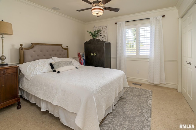 carpeted bedroom with crown molding and ceiling fan