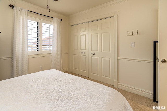 carpeted bedroom featuring crown molding and a closet