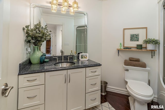 bathroom with vanity, hardwood / wood-style flooring, toilet, and an inviting chandelier