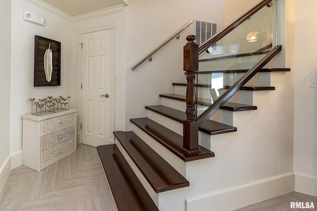 staircase with parquet floors and ornamental molding