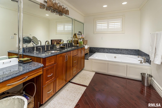 bathroom featuring a tub to relax in, vanity, plenty of natural light, ornamental molding, and hardwood / wood-style flooring