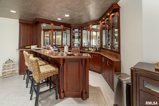 bar featuring light parquet flooring and a textured ceiling