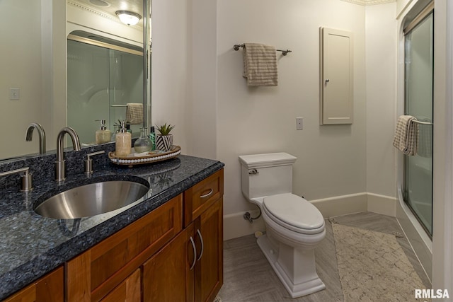 bathroom featuring vanity, an enclosed shower, and toilet
