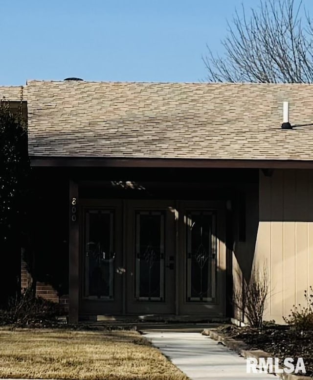 entrance to property with a shingled roof