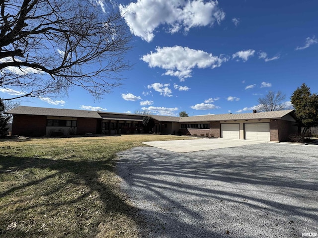 ranch-style home featuring driveway, an attached garage, a front lawn, and brick siding