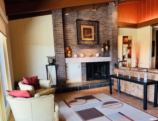 living area featuring wooden walls, a tile fireplace, beam ceiling, and tile patterned floors