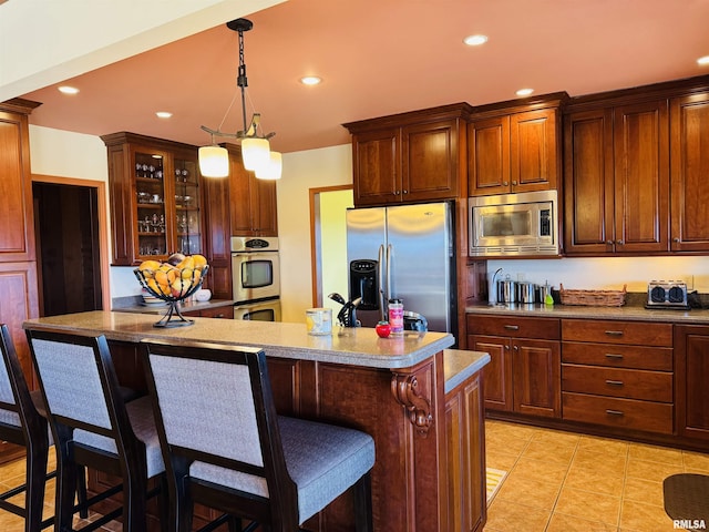 kitchen with stainless steel appliances, recessed lighting, glass insert cabinets, and a kitchen breakfast bar