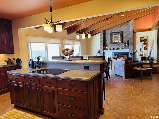 kitchen featuring lofted ceiling, light tile patterned floors, black electric stovetop, a fireplace, and open floor plan