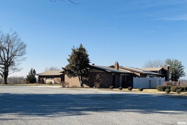 view of front of home with fence and a chimney