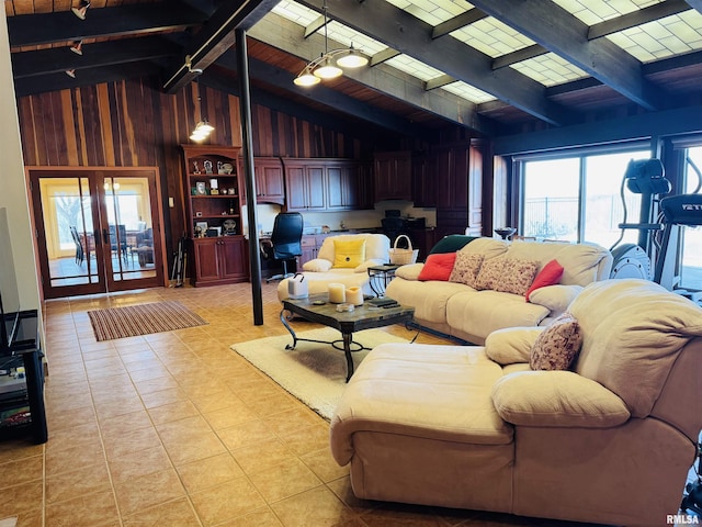 living room with lofted ceiling with beams, french doors, a wealth of natural light, and wooden walls