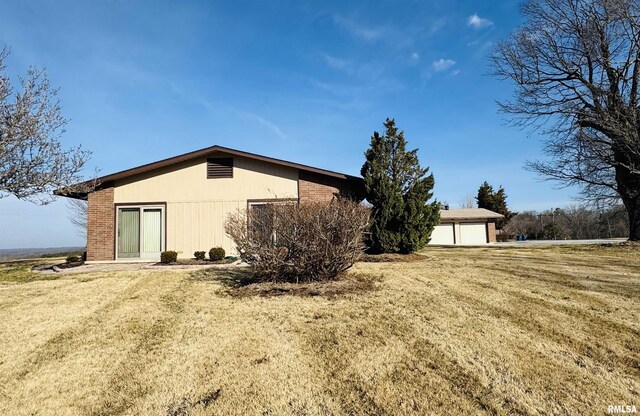 view of side of property featuring brick siding and a lawn