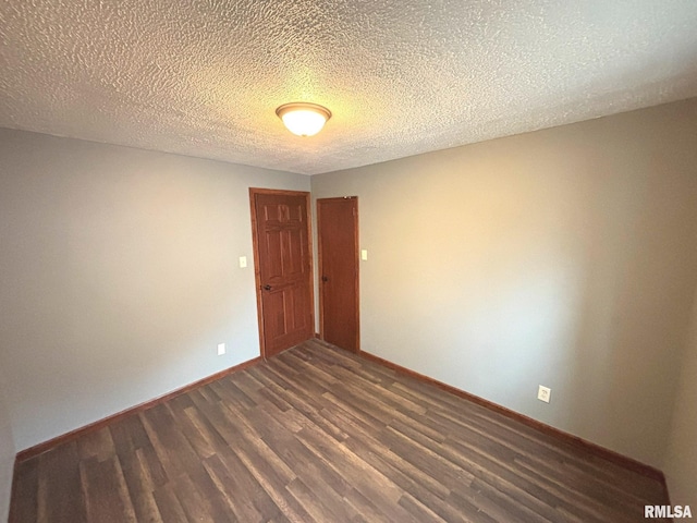 spare room with dark hardwood / wood-style flooring and a textured ceiling