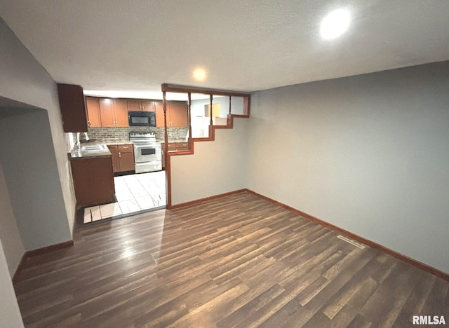 kitchen with tasteful backsplash, sink, dark hardwood / wood-style flooring, and stainless steel range with electric stovetop