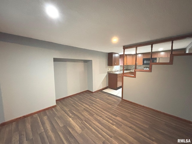 basement with dark hardwood / wood-style floors and a textured ceiling