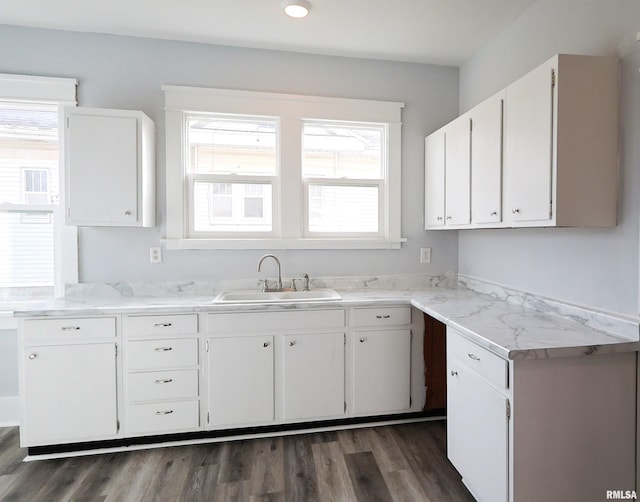 kitchen with dark wood-type flooring, plenty of natural light, sink, and white cabinets