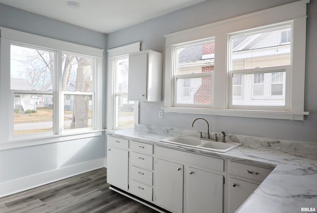 kitchen featuring light stone countertops, sink, white cabinets, and dark hardwood / wood-style floors