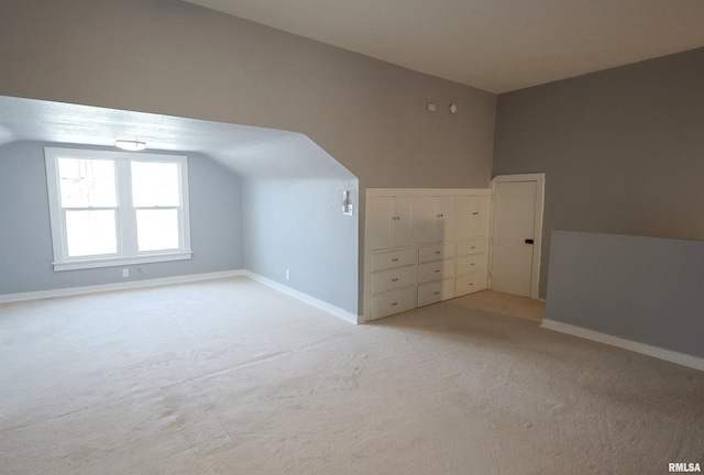 bonus room featuring vaulted ceiling and light colored carpet