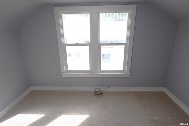 bonus room with vaulted ceiling, a healthy amount of sunlight, and carpet flooring