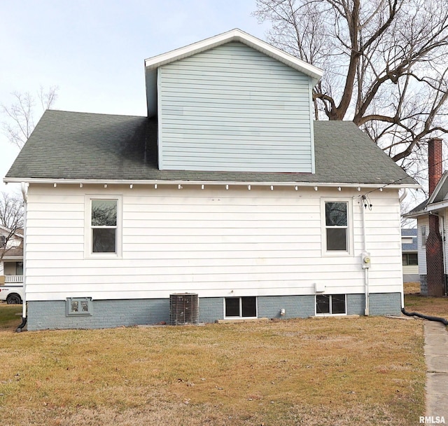 view of side of home with a yard and central AC