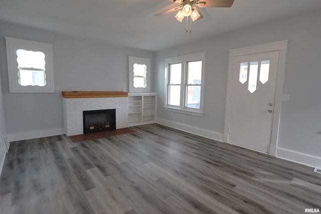 unfurnished living room featuring dark hardwood / wood-style flooring, ceiling fan, and a fireplace