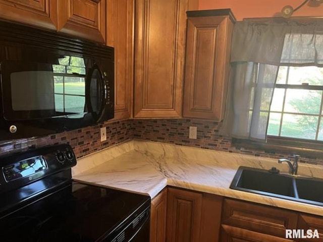 kitchen featuring tasteful backsplash, sink, and black appliances