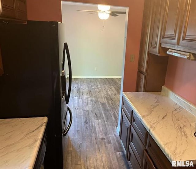 kitchen featuring black refrigerator, ceiling fan, and dark wood-type flooring