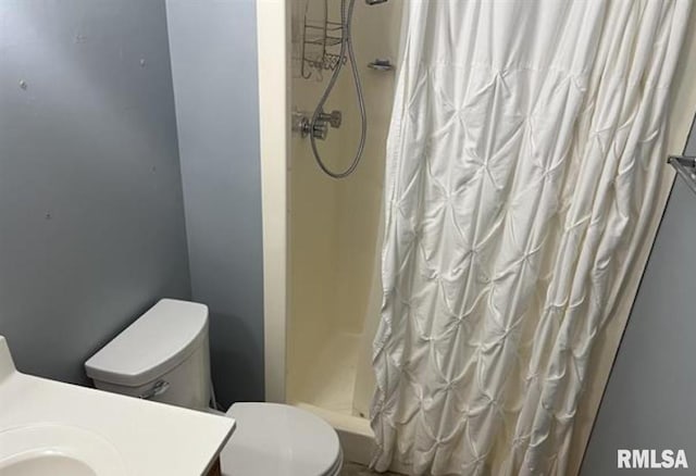 bathroom featuring toilet and a shower with shower curtain