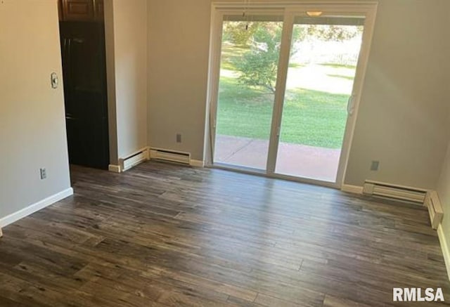 spare room with dark hardwood / wood-style flooring and a baseboard heating unit