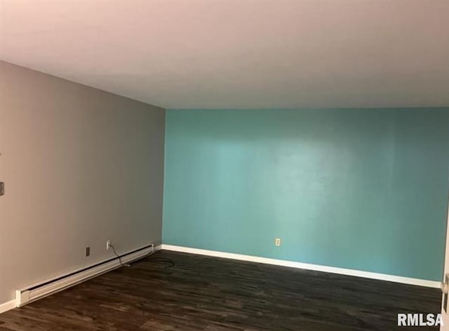 spare room with dark hardwood / wood-style floors and baseboard heating