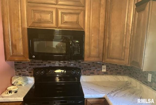 kitchen with light stone counters, backsplash, and black appliances