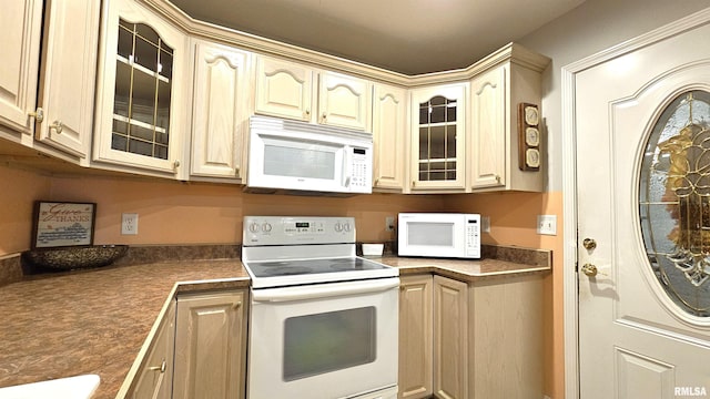 kitchen featuring light brown cabinetry and white appliances