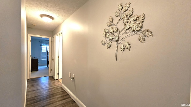 hallway with dark hardwood / wood-style flooring and a textured ceiling